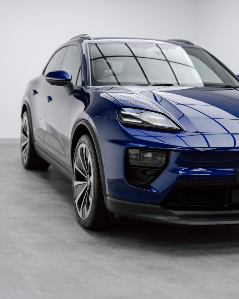 Blue Porsche Macan Electric front three-quarter view in a studio, protected by Defcon Films Australia gloss paint protection film